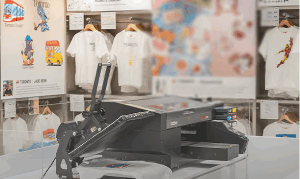 Picture of the UT space in UNIQLO, grapchis tees hanging and laser pirnter in the table